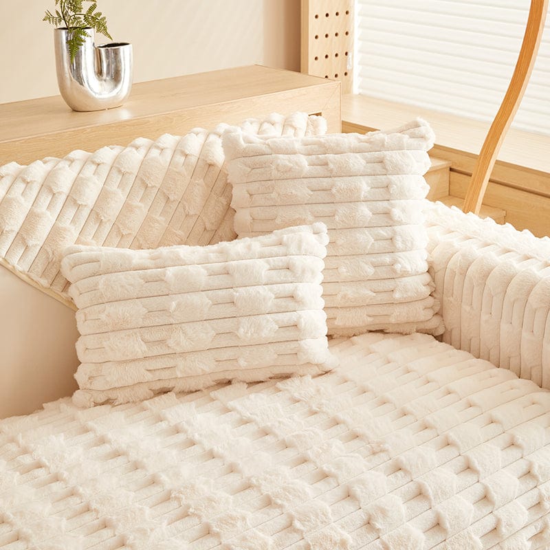 Housse de coussin en fausse fourrure blanche sur canapé