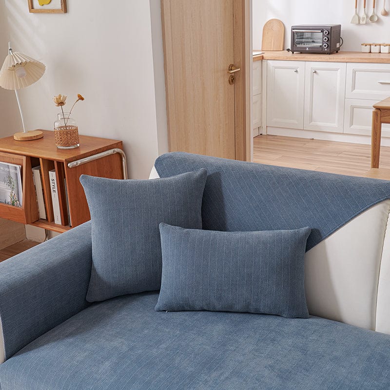Housse de coussin bleu en tissu chenillé sur canapé