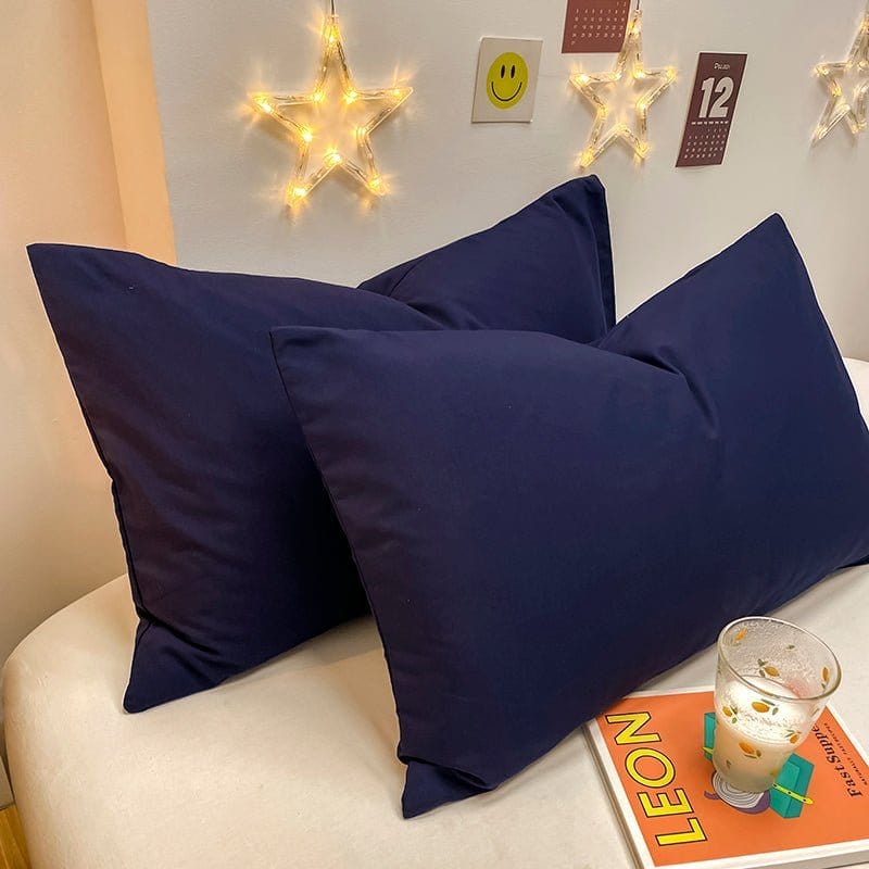 Deux housses de coussin bleu marine sur fond blanc