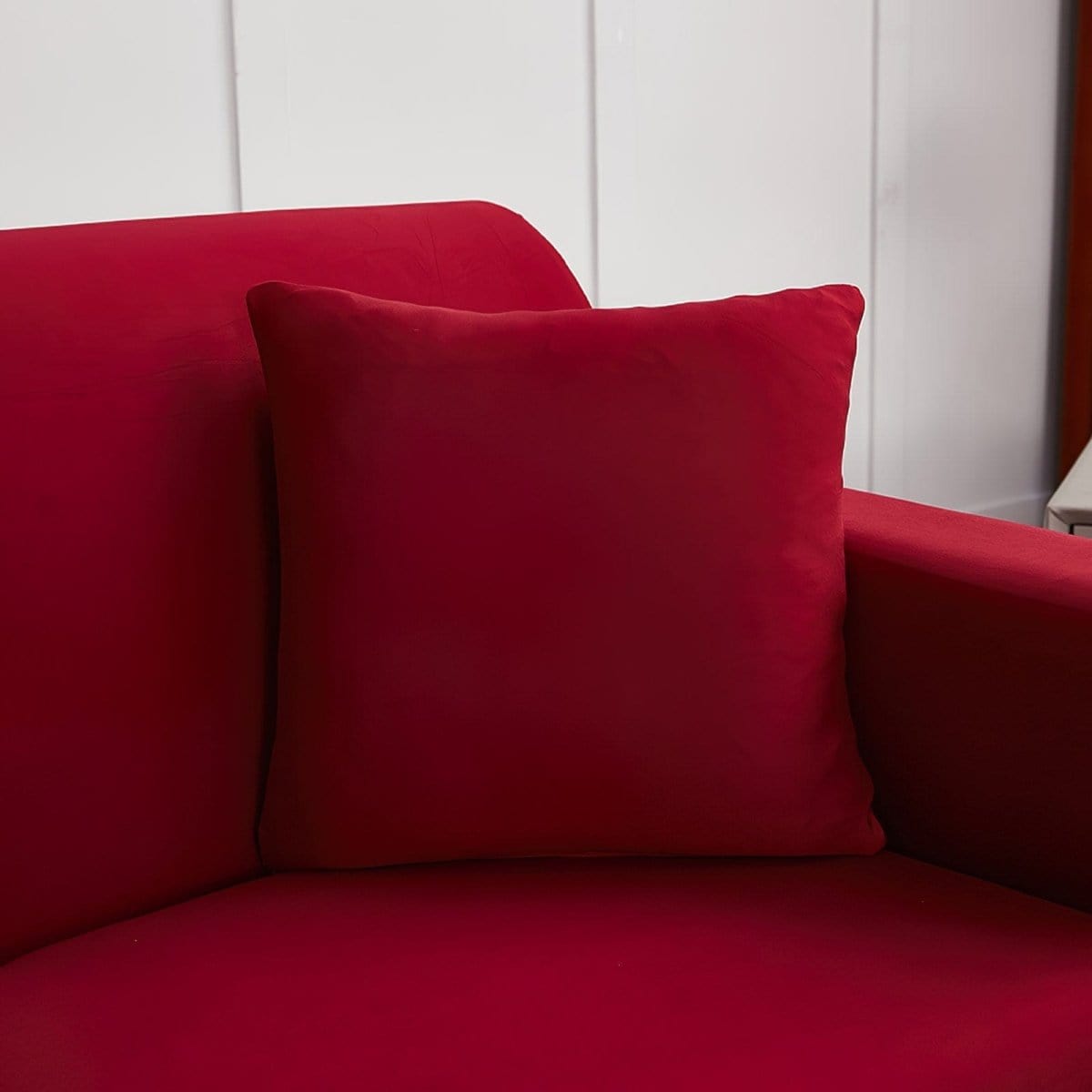 Deux housses de coussin bordeaux extensibles sur fond neutre