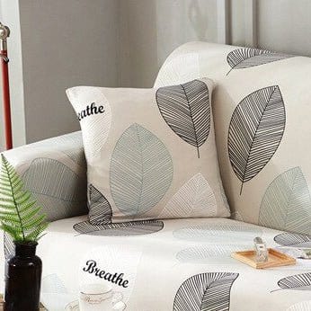 Deux housses de coussin extensibles en tissu gris sur canapé