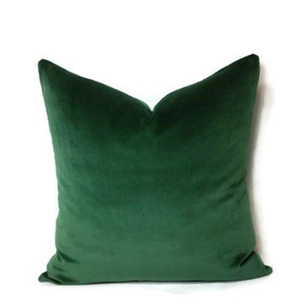Deux housses de coussin vert forêt sur canapé