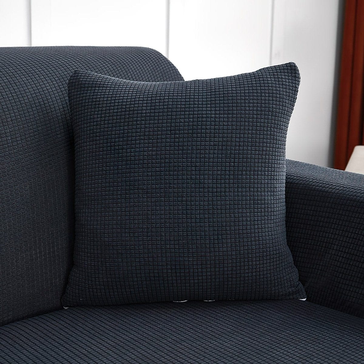 Housse de coussin grise déperlante sur canapé moderne