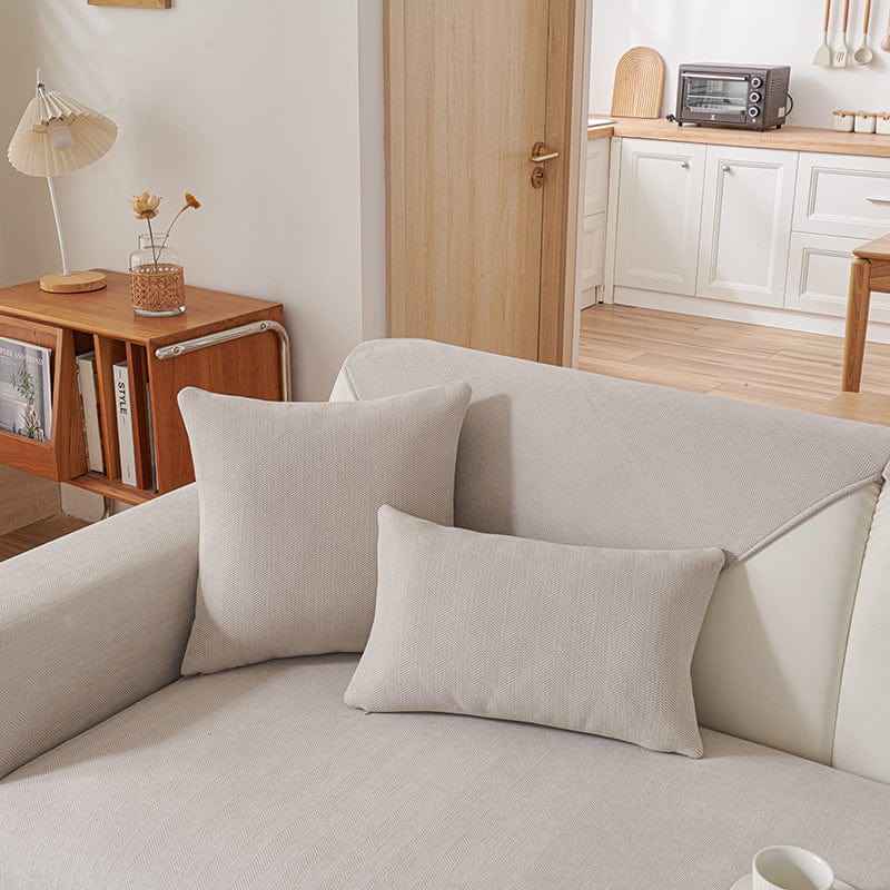 Housse de coussin gris clair en tissu chenillé sur canapé