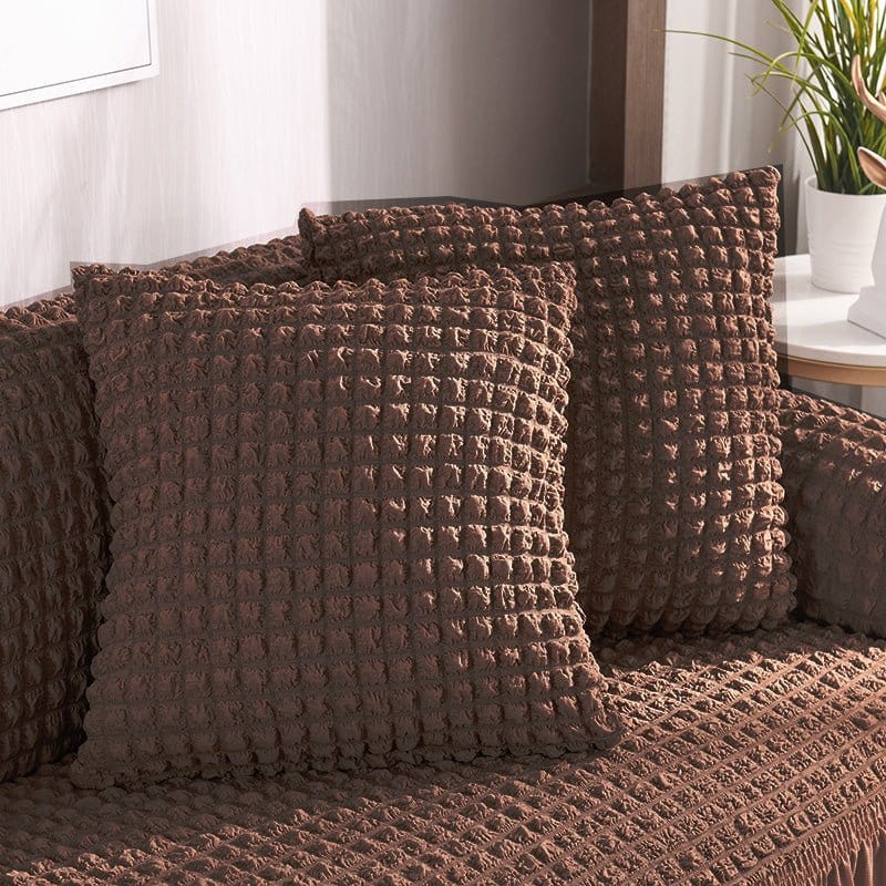 Deux housses de coussin marron extensibles sur fond blanc