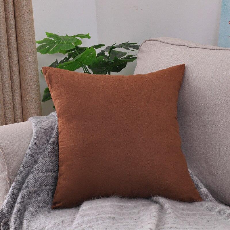 Deux housses de coussin marron extensibles sur un canapé