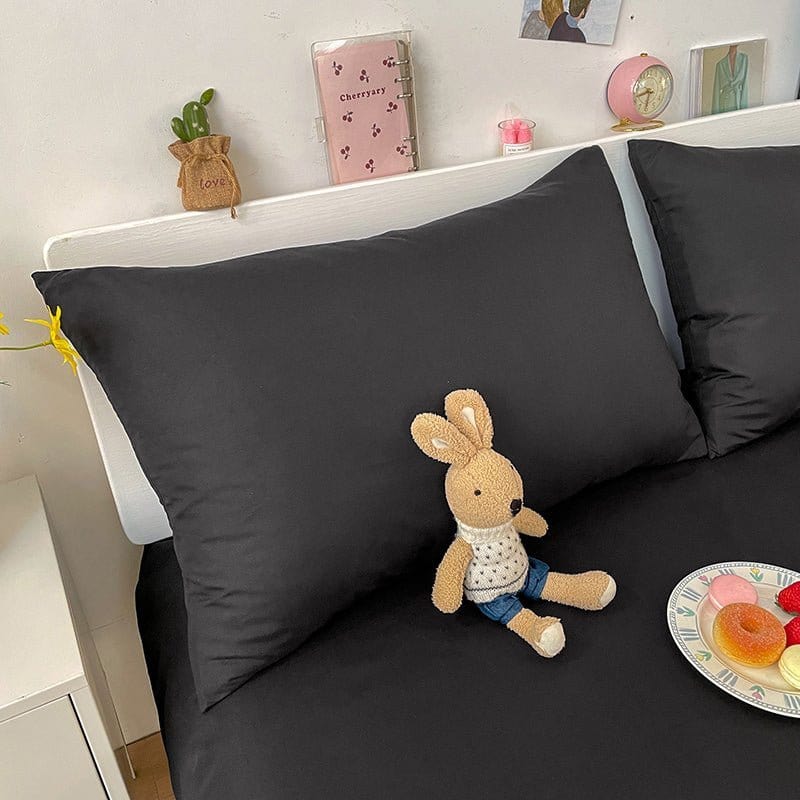 Deux housses de coussin noires en tissu résistant sur fond blanc