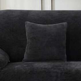 Deux housses de coussin noires en velours sur un canapé