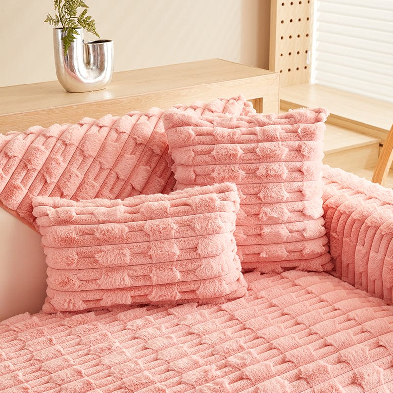 Housse de coussin en fausse fourrure rose sur canapé