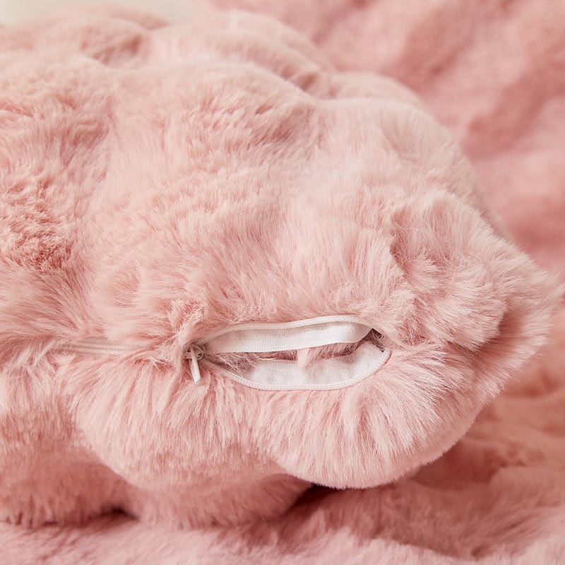 Housse de coussin rose en fausse fourrure sur canapé