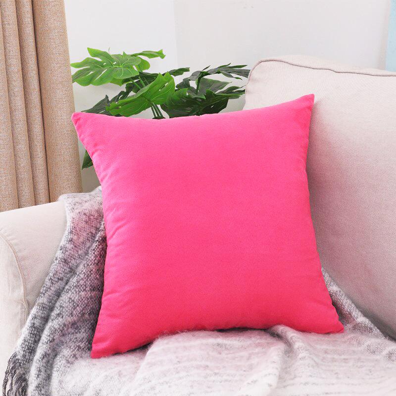 Deux housses de coussin roses extensibles sur un canapé