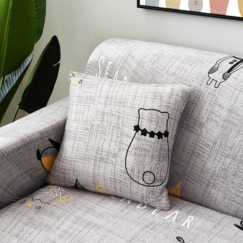 Deux housses de coussin extensibles sur un canapé beige