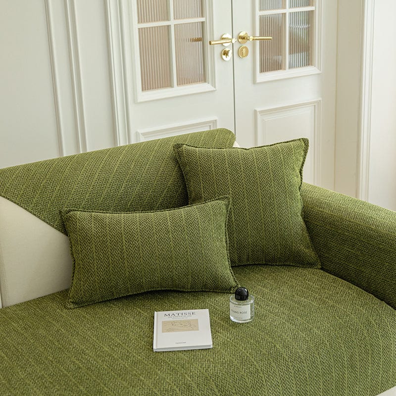 Housse de coussin verte en tissu herringbone sur canapé moderne