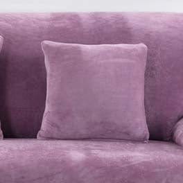 Deux housses de coussin violettes en velours sur un canapé