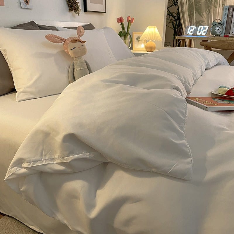 Housse de couette blanche en polyester sur un lit fait