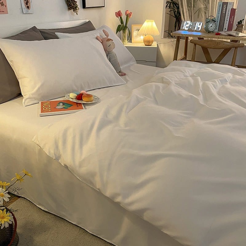 Housse de couette blanche étalée sur un lit double