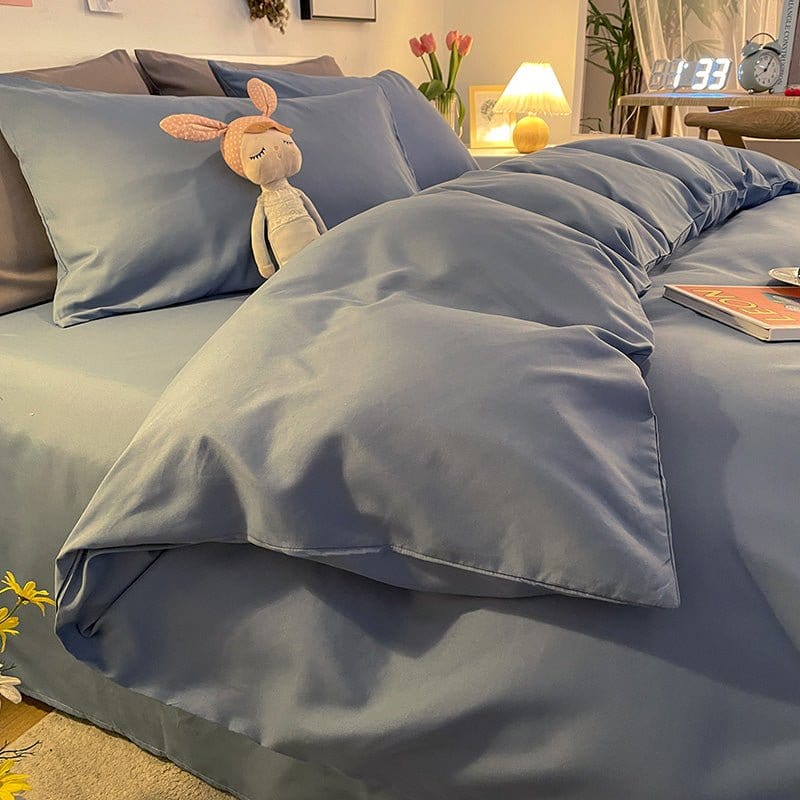 Housse de couette bleu sur lit avec coussins assortis