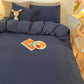 Lit avec housse de couette bleu marine et coussins décoratifs