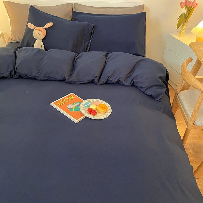 Lit avec housse de couette bleu marine et coussins décoratifs
