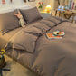 Housse de couette grise en polyester sur un lit bien fait