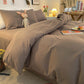 Housse de couette grise présentée sur un lit moderne