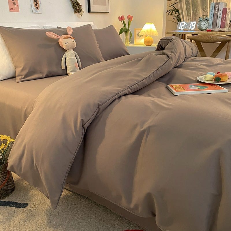 Housse de couette grise présentée sur un lit moderne