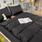 Housse de couette noire posée sur un lit blanc