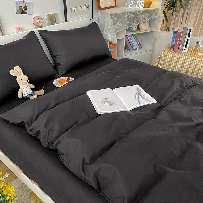 Housse de couette noire posée sur un lit blanc