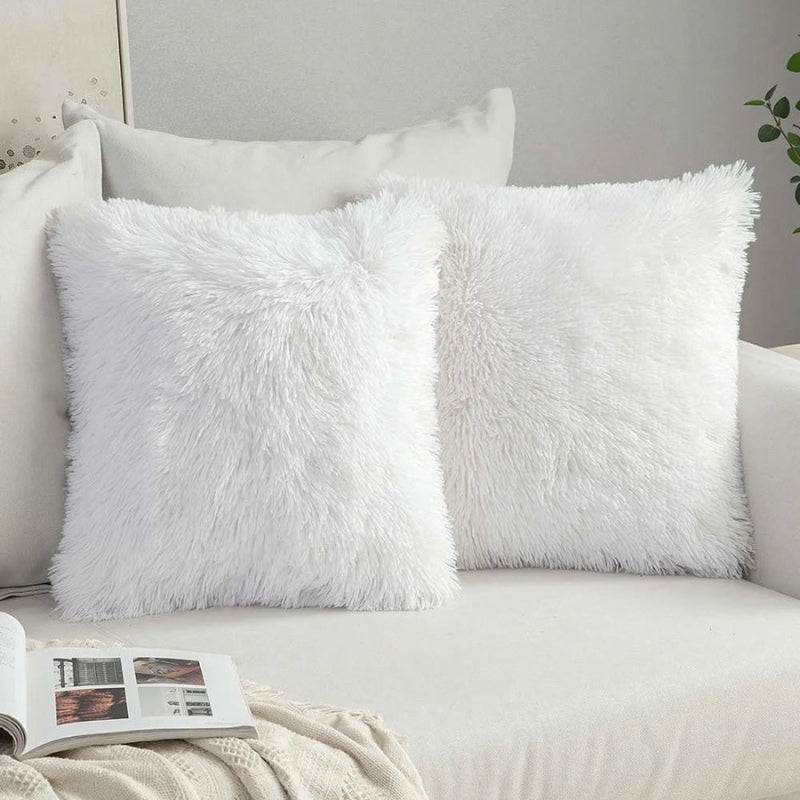 Housse de coussin blanche en bouclette sur canapé gris