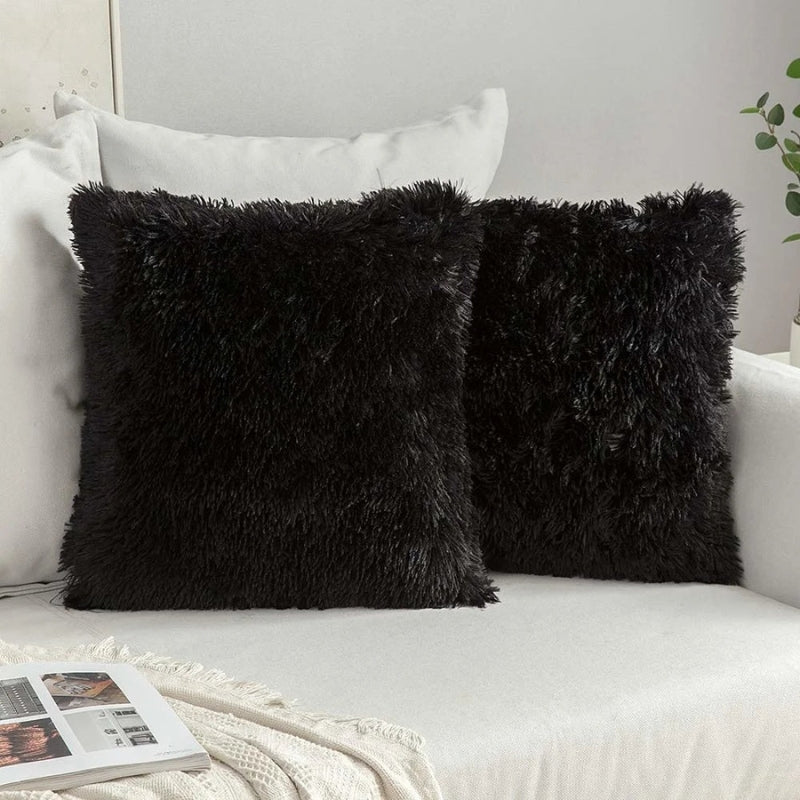 Housse de coussin noire en matière moutonnée sur canapé