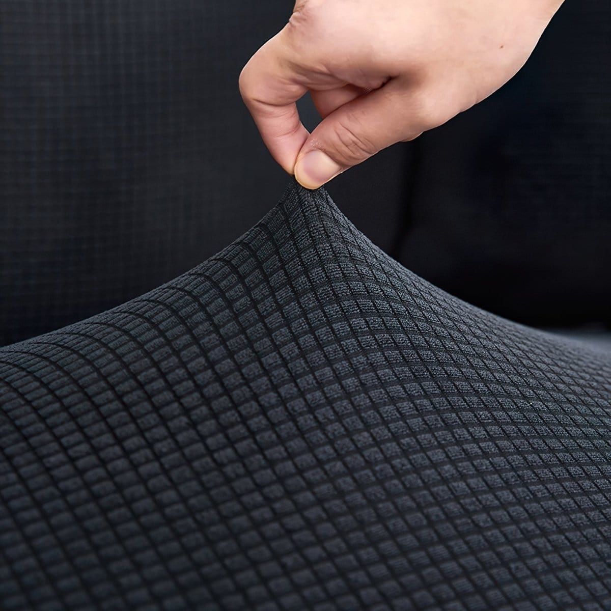 Housse grise sur fauteuil, tissu extensible et ajusté