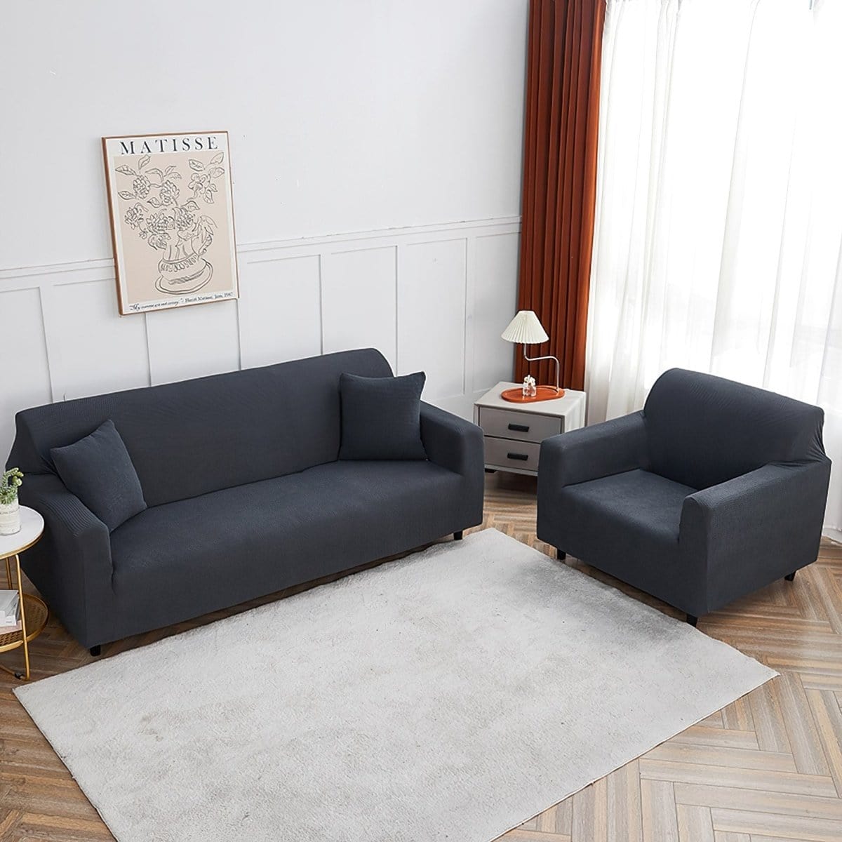 Housse grise couvrant un fauteuil, protection anti-taches visible