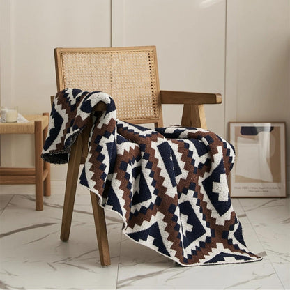 Couverture moumoute beige et grise sur lit moderne