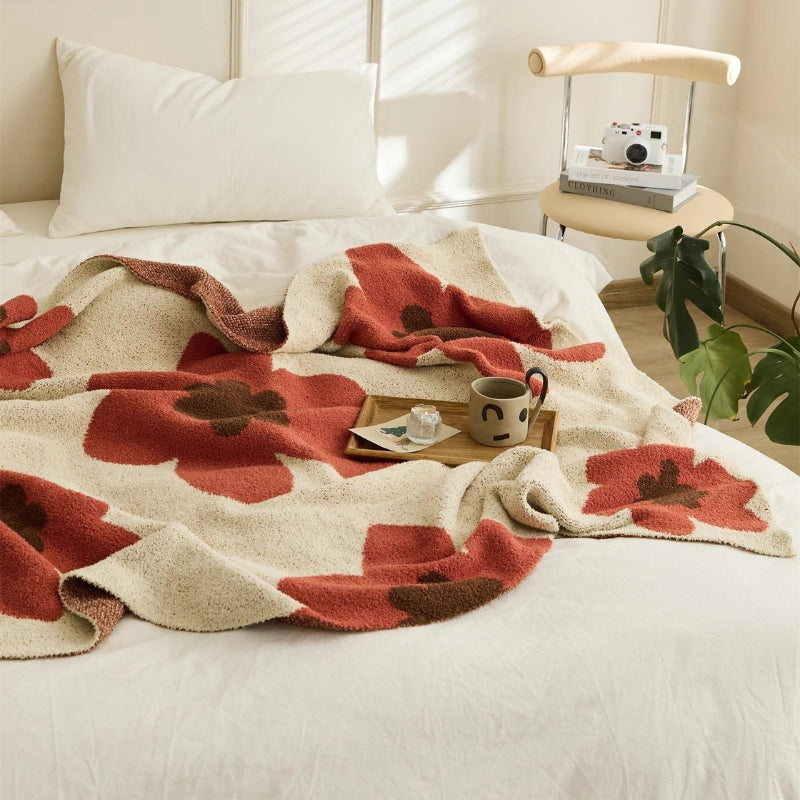 Plaid étalé sur un lit, mettant en valeur son design floral