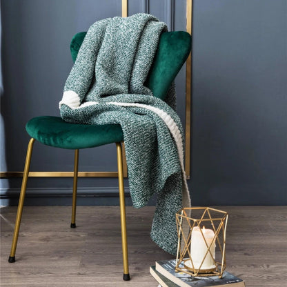 Plaid vert enroulé, posé sur une chaise