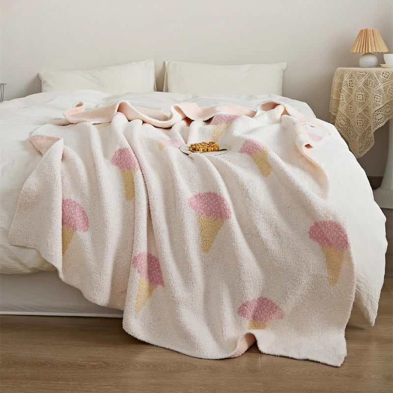 Plaid rose pâle étendu sur un lit, motifs visibles