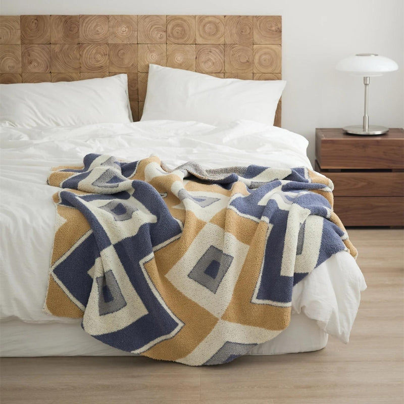 Plaid polaire harmonieux drapé sur un canapé clair