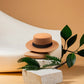 Chapeau Fedora marron posé sur une table en bois clair
