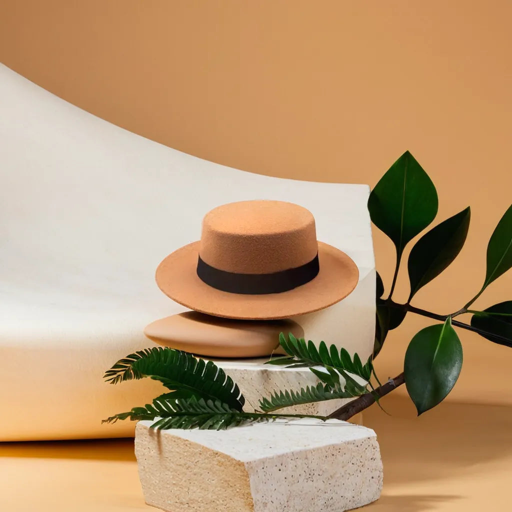 Chapeau Fedora marron posé sur une table en bois clair