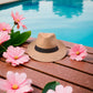 Chapeau de paille posé sur une table en bois, lumière naturelle