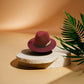 Chapeau Fedora marron posé sur une table en bois