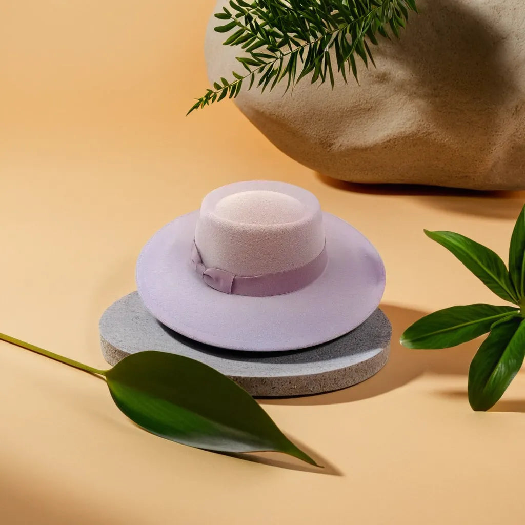 Chapeau fedora marron posé sur une table en bois clair