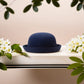 Chapeau melon avec doublure intérieure visible, posé sur une table