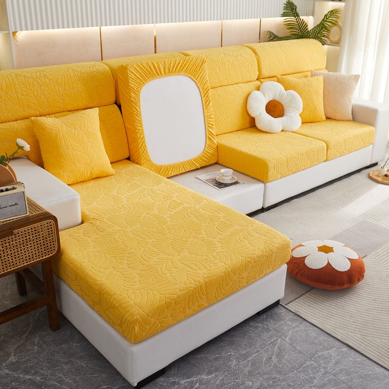 Housse polaire jaune installée sur un canapé, motif palmier visible