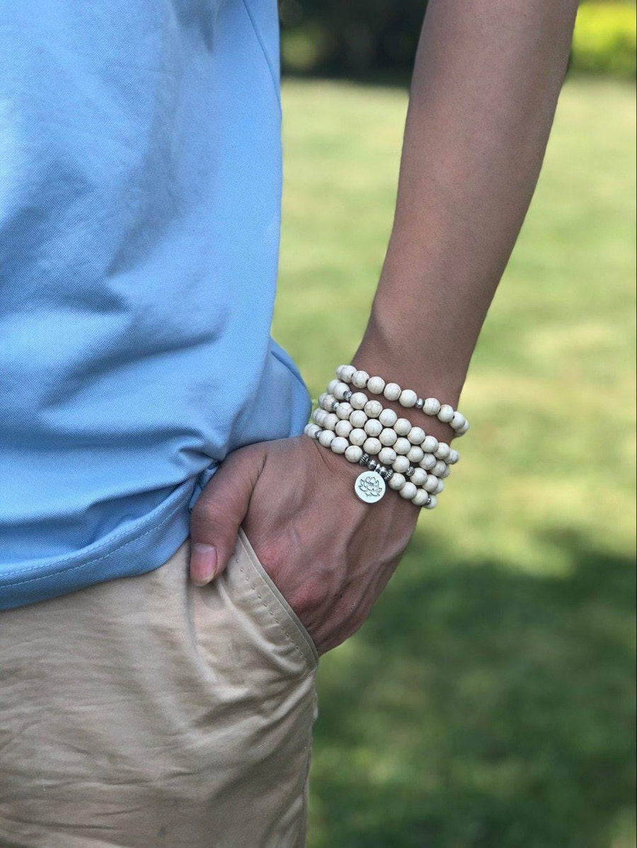 Vue rapprochée du mala avec perles en howlite et symbole OM