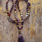 Gros plan sur les perles violettes et translucides du Mala