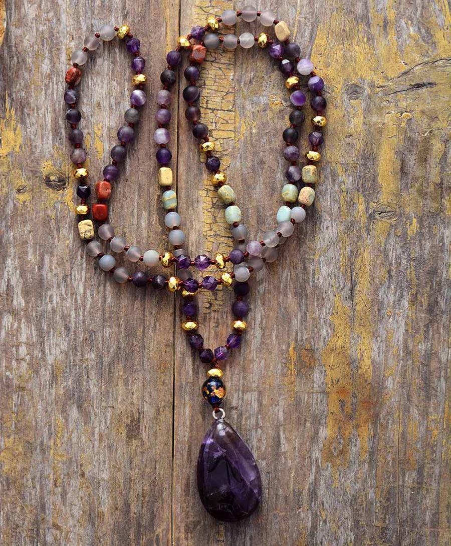 Gros plan sur les perles violettes et translucides du Mala