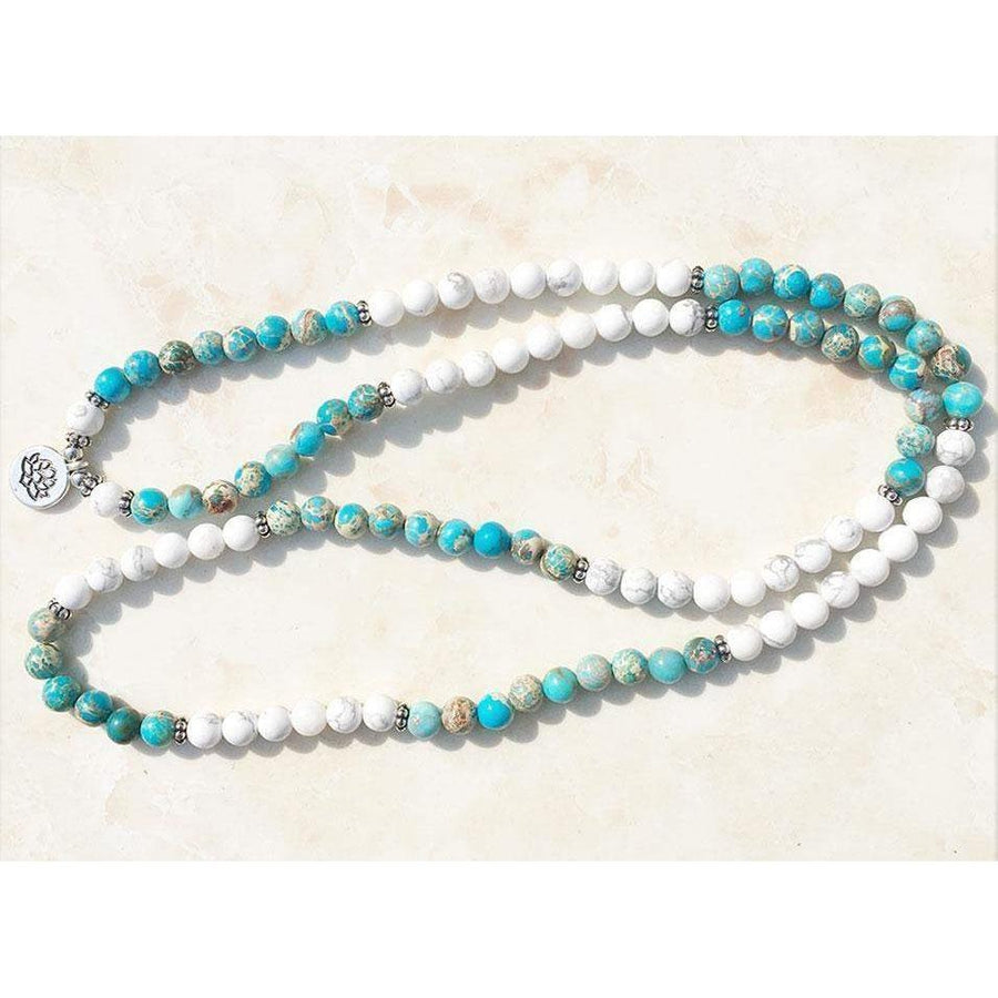 Gros plan sur les perles de howlite et jaspe du mala