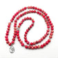 Détail du symbole Om sur le Mala en régatite rouge