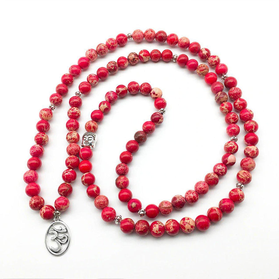Détail du symbole Om sur le Mala en régatite rouge